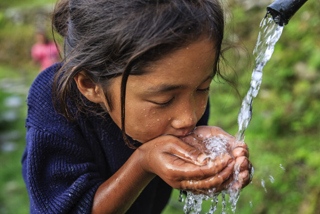 Nepali girl drinking fresh water