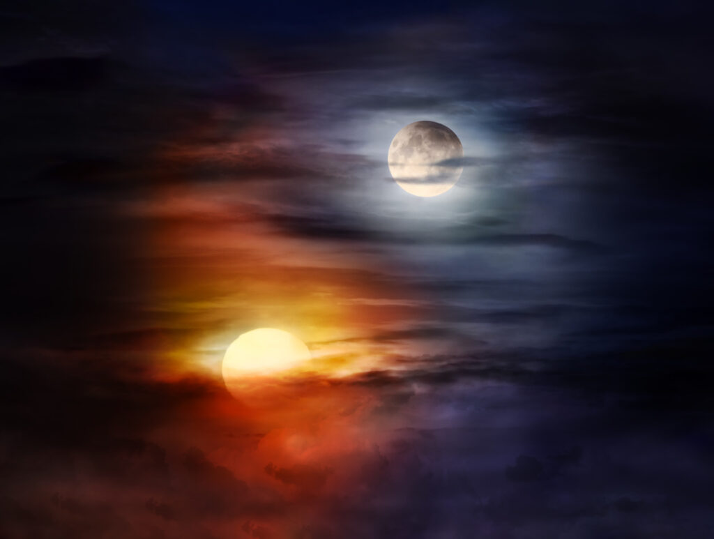 Sun and moon on a cloudy sky forming Yin Yang balance 